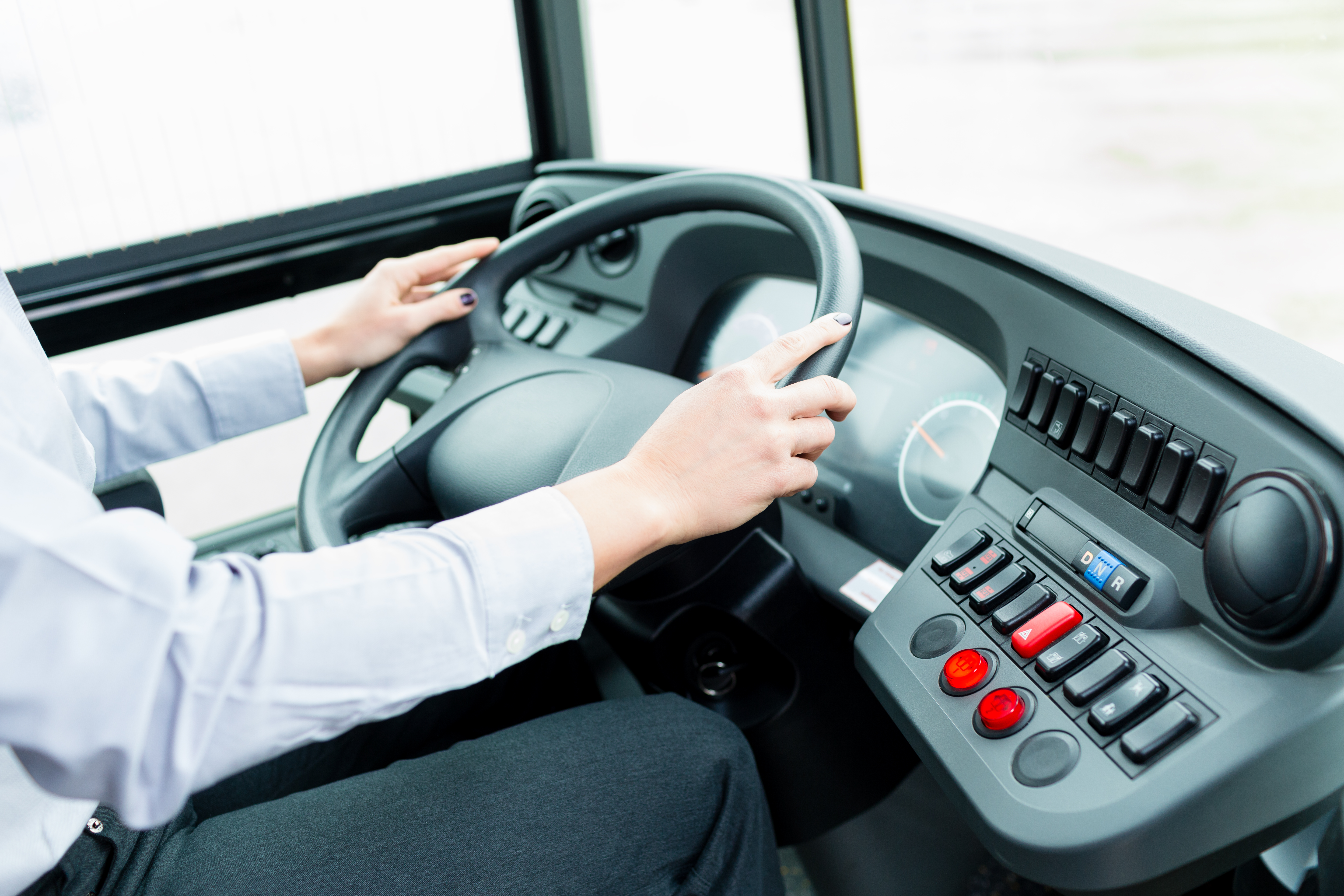 Bus driver in cockpit at the wheel driving