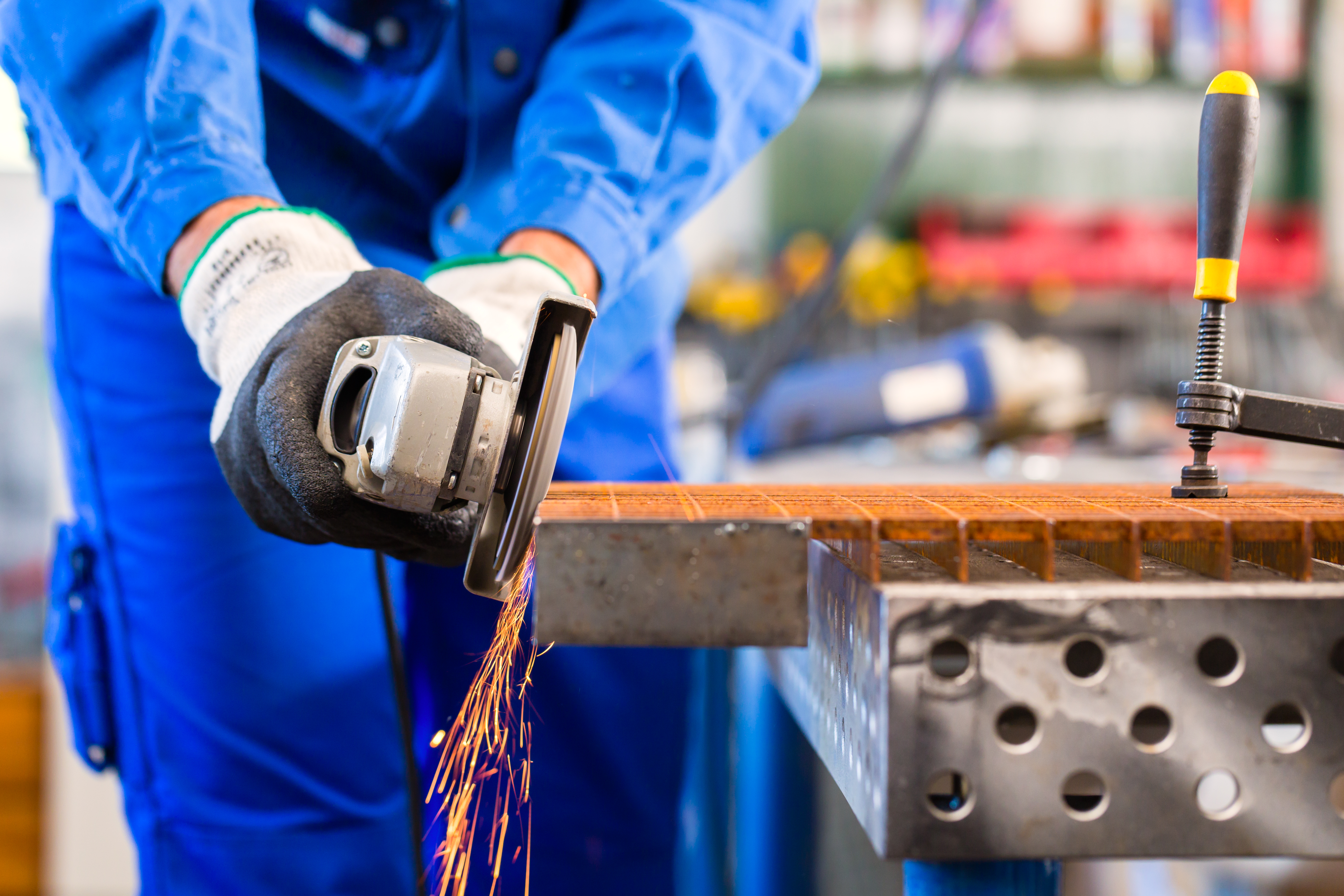 Metal wroker in a factory grinding with sparks