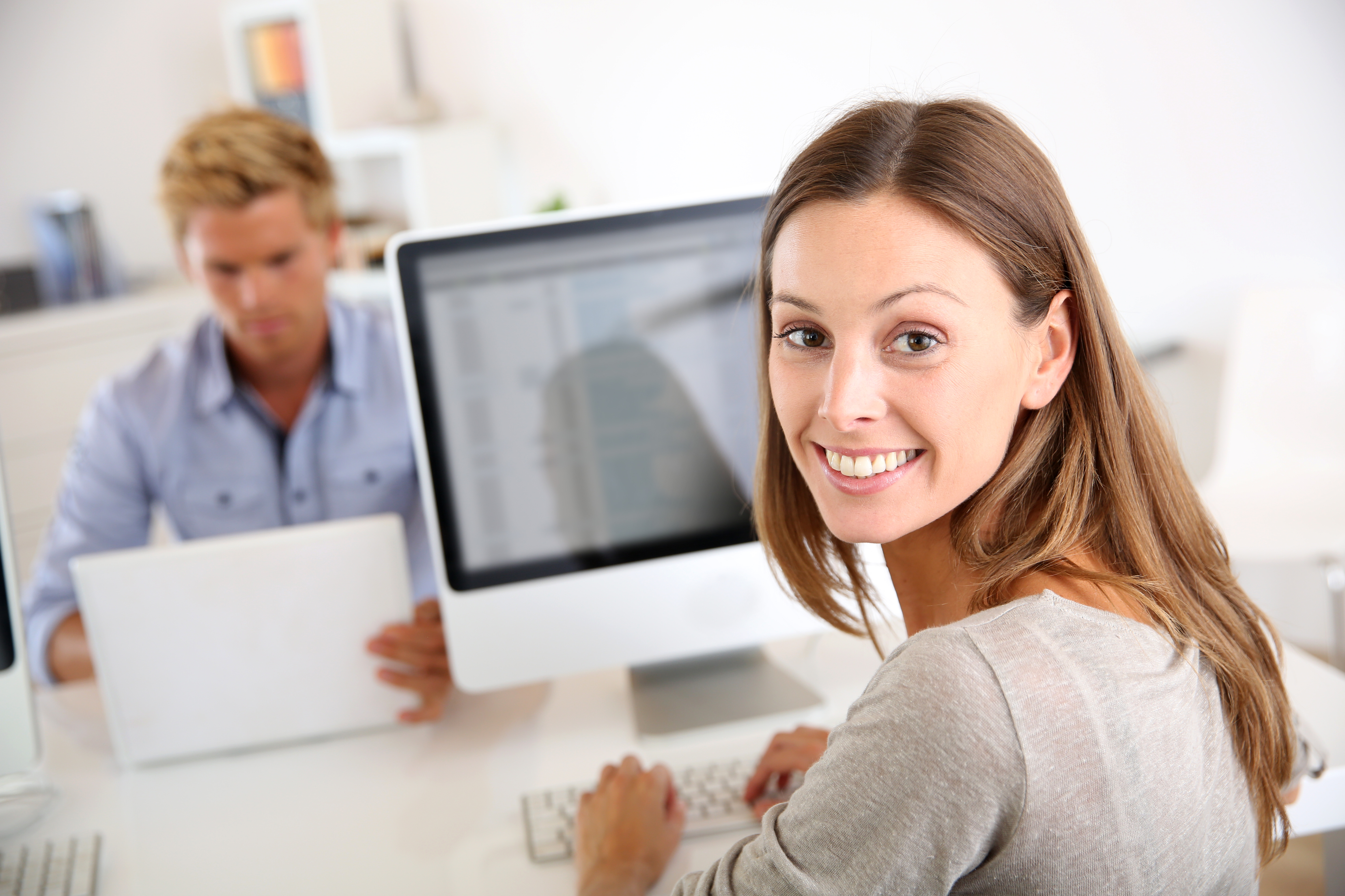 Portrait of smiling office worker in front of desktop