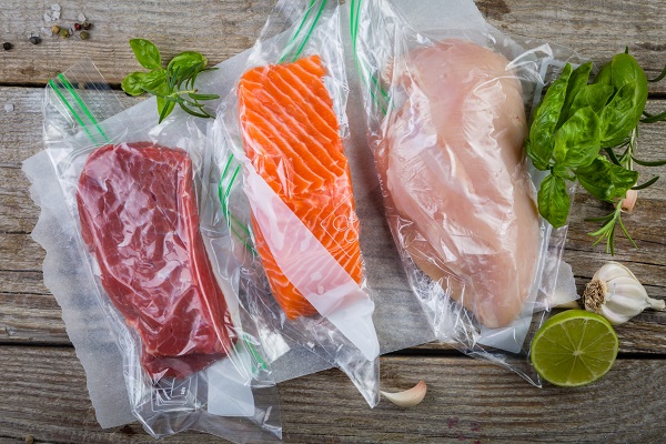 Beef, chicken and salmon in vacuum plastic bag for sous vide cooking, copy space