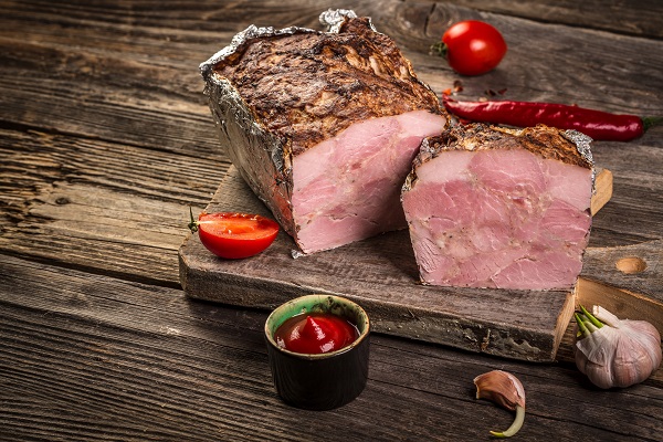 Traditional French Pate en croute with goose meat and liver as closeup on a wooden board.