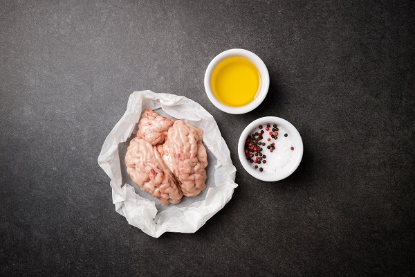 Raw brains and ingredients for cooking fried brains on stone dark table. Calf or beef brains. Gourmet food. Top view and copy space