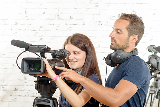 a young man and a young woman cameramen with professional video camera